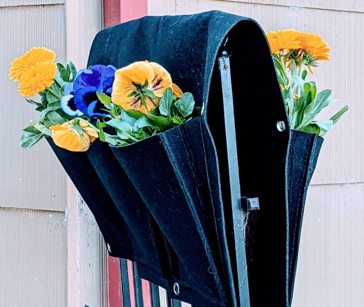 Cloth 6 pocket saddlebag hanging vertical garden planter with colorful flowers on a fence