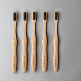 Bamboo toothbrush bundle (5-pack) with ergonomic handles and medium wavy bristles for eco-friendly oral care.