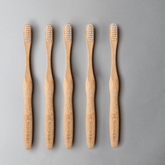 Bamboo toothbrush bundle, five eco-friendly brushes with ergonomic handles, promoting zero waste living.