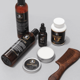Full Beard Grooming Kit featuring beard wash, balm, oil, conditioner, and comb on gray background.
