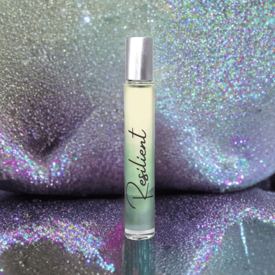 Resilient Rollerball Perfume with a blend of sandalwood and vanilla, set against a shimmering glitter background.