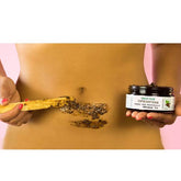 Woman applying Coffee Scrub on skin with natural wooden spatula, showcasing hydration and exfoliation benefits.