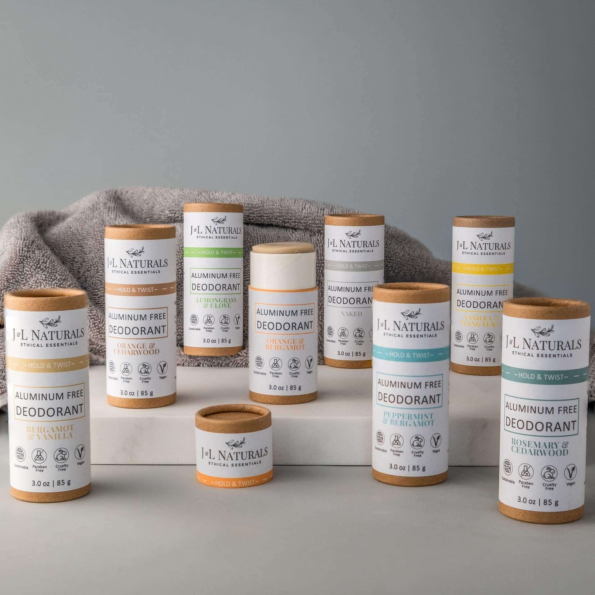 Collection of aluminum-free deodorants by J.L. Naturals on display with a soft towel in the background.