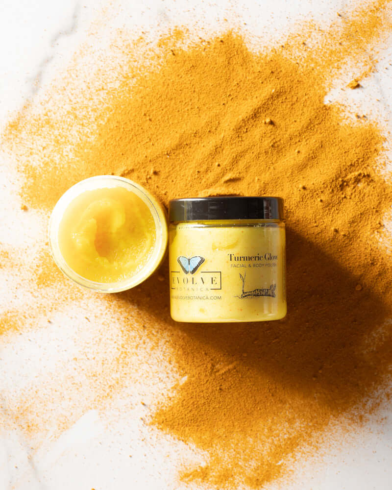 Turmeric Glow Facial Polish jar surrounded by turmeric powder, designed to brighten and nourish skin.