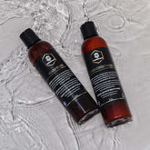 Beard wash and conditioner set in amber bottles, surrounded by water, ideal for a clean and soft beard.