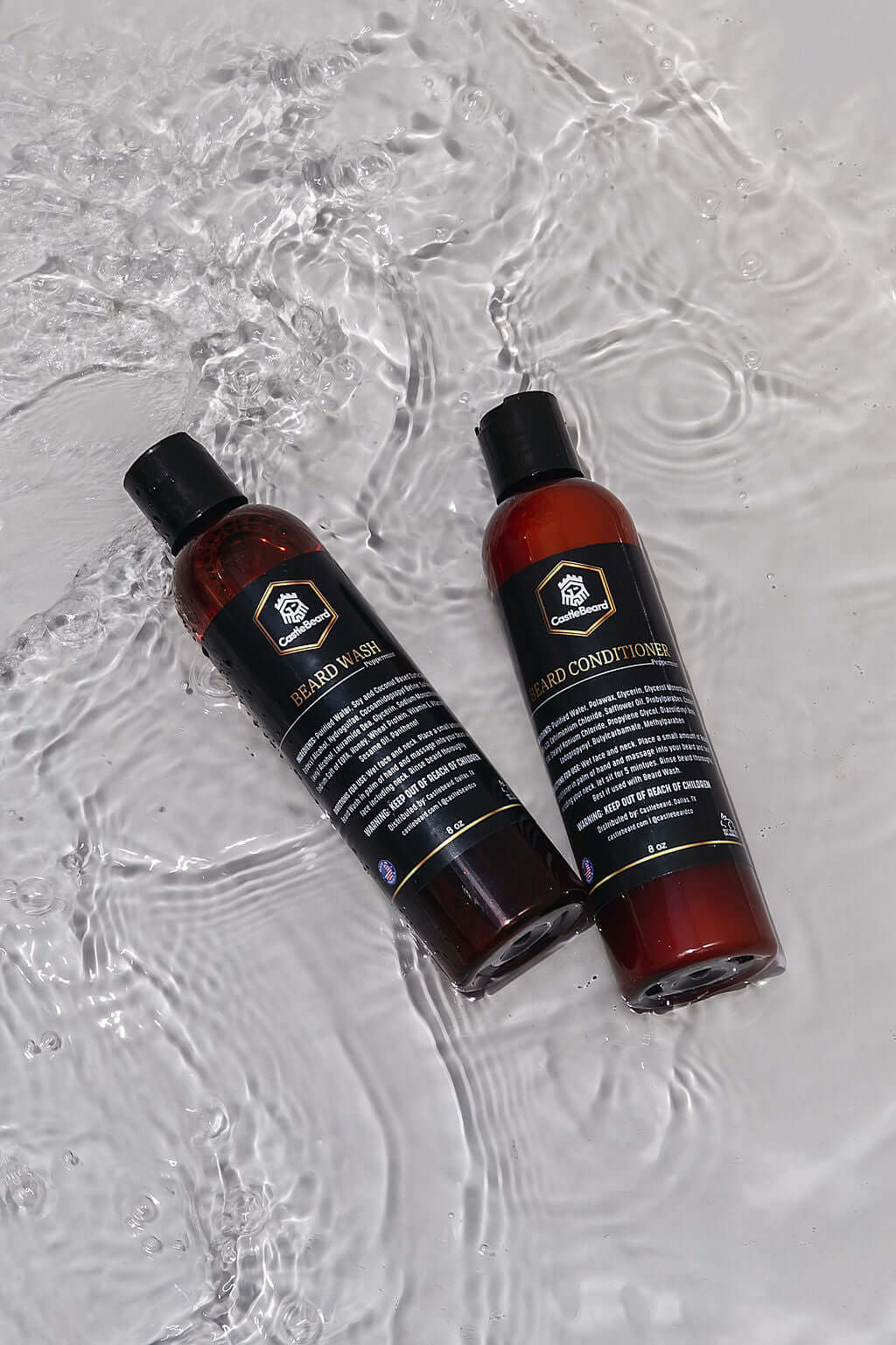 Beard wash and conditioner set bottles on wet surface, designed for cleaning and conditioning beards without stripping oils.