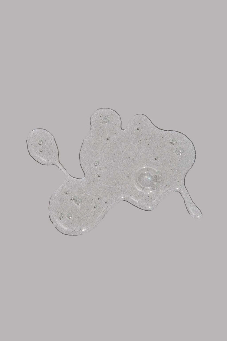 Transparent beard wash gel with bubbles on a grey background.
