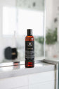 Beard wash bottle displayed in a modern bathroom setting, designed for cleaning and conditioning beards.
