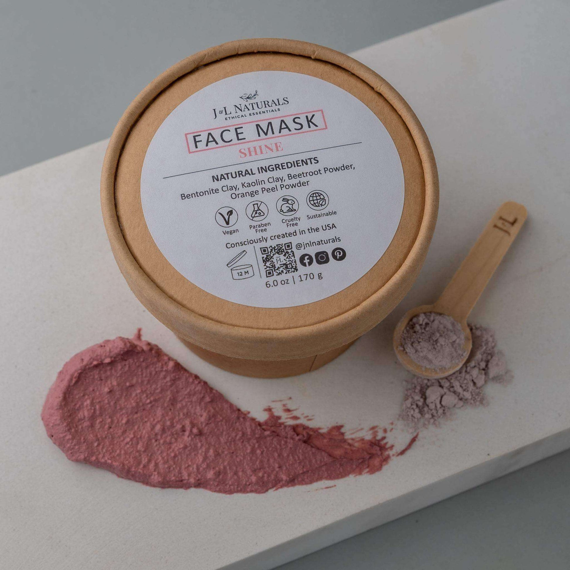 J.L. Naturals Face Mask Shine with natural ingredients for glowing skin, displayed with powders on a countertop.