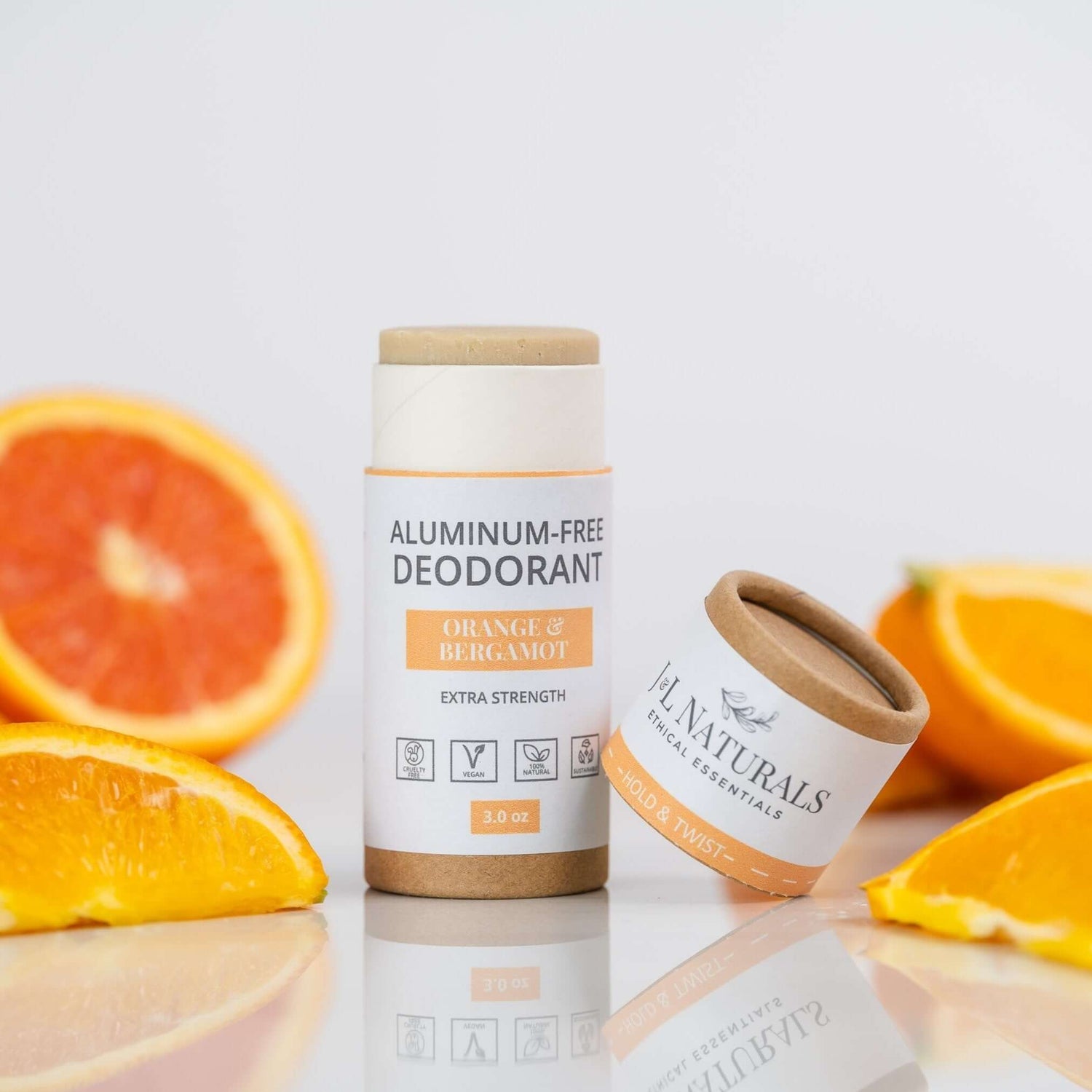 Extra-strength aluminum-free deodorant in Orange & Bergamot scent with fresh oranges in the background.