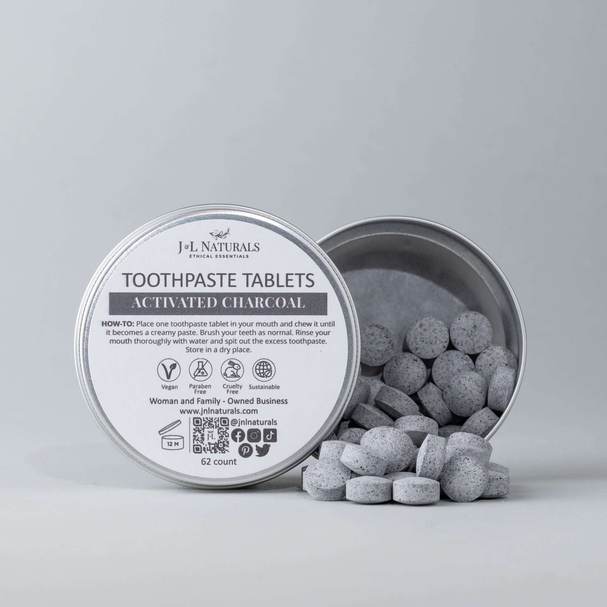 Eco-friendly activated charcoal toothpaste tablets in a metal container, promoting sustainable dental hygiene.