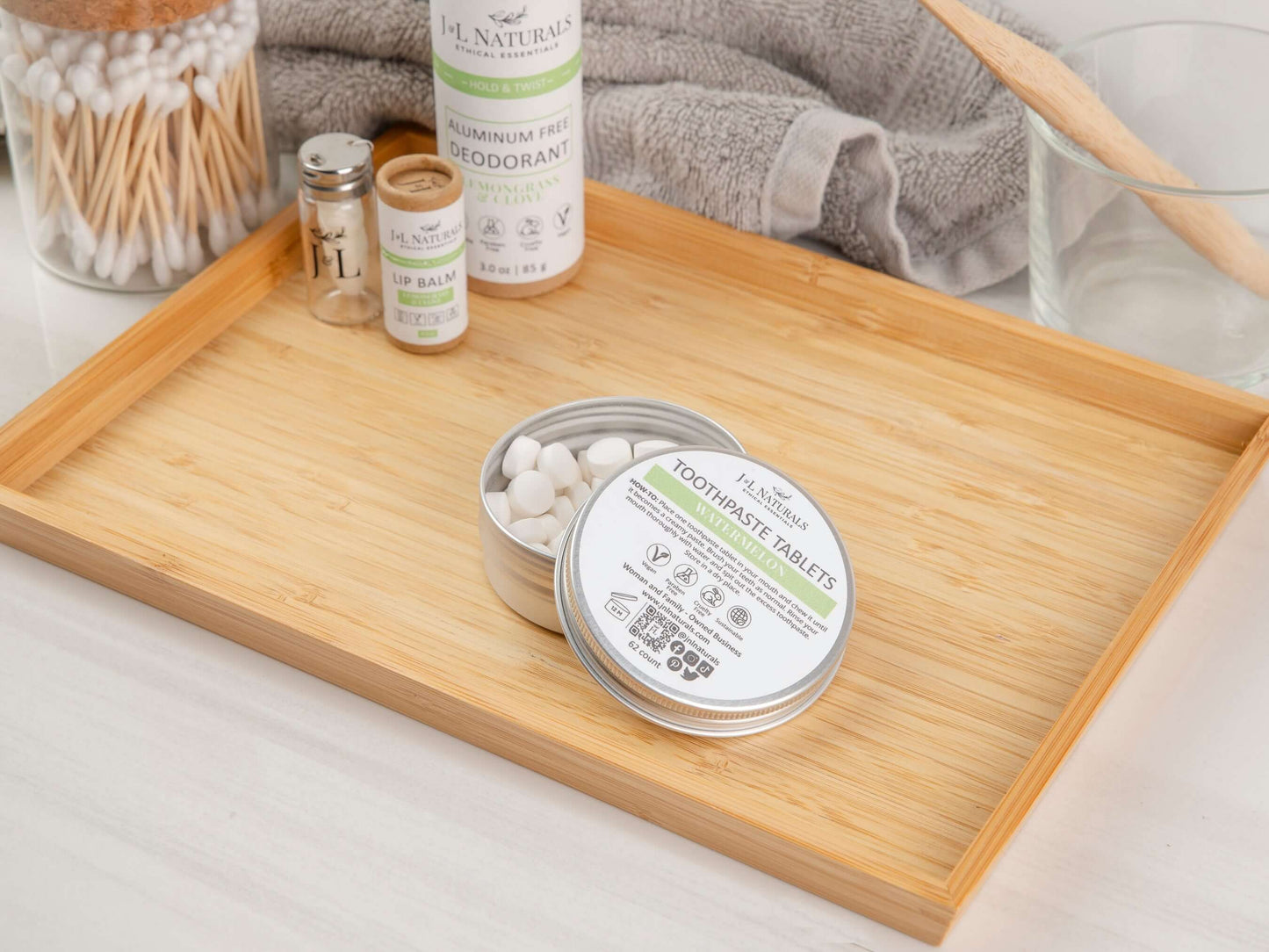 Eco-friendly toothpaste tablets in a tin on a bamboo tray, promoting a sustainable dental care routine.