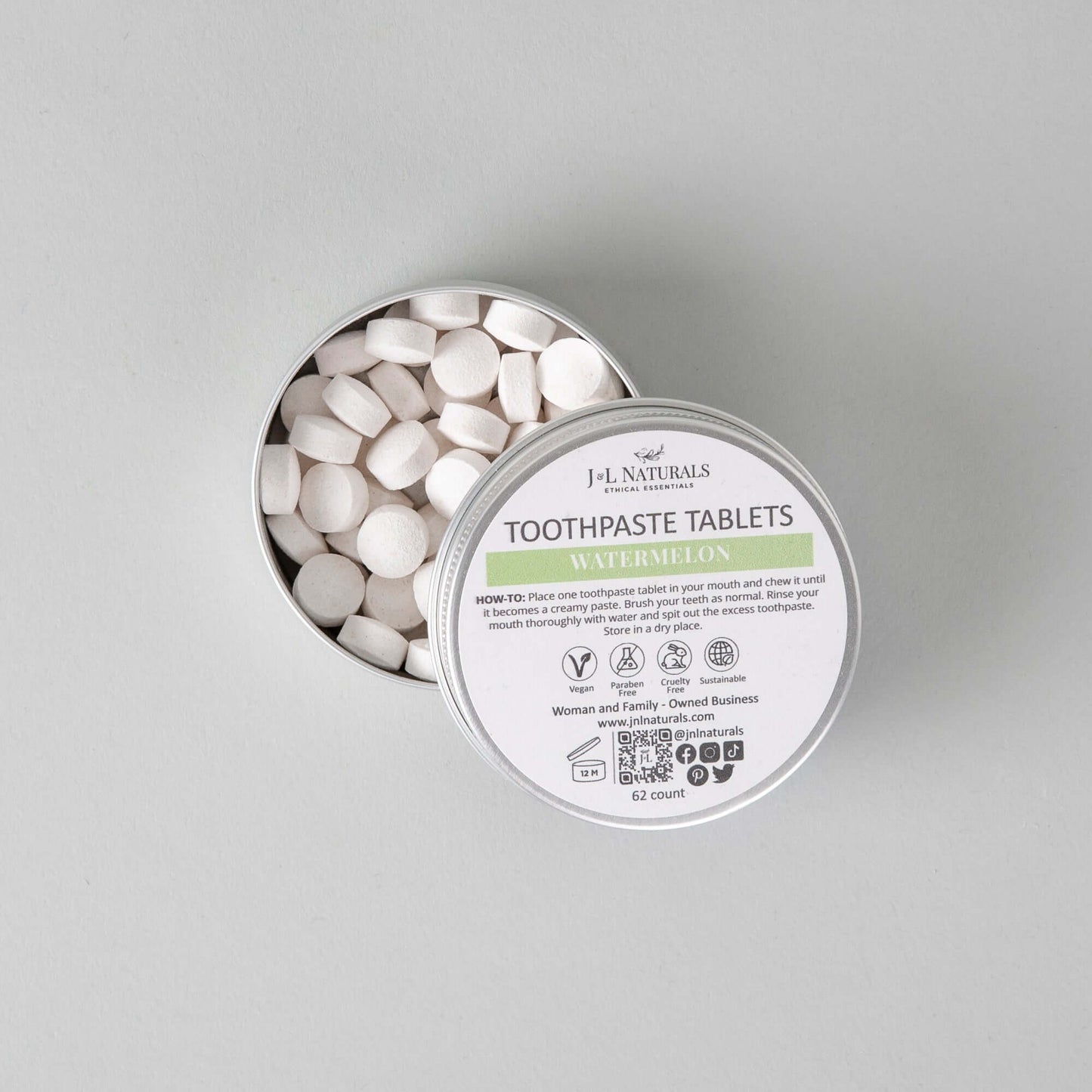 Eco-friendly toothpaste tablets in a tin, featuring a watermelon flavor and a 62-count supply for fresher dental hygiene.