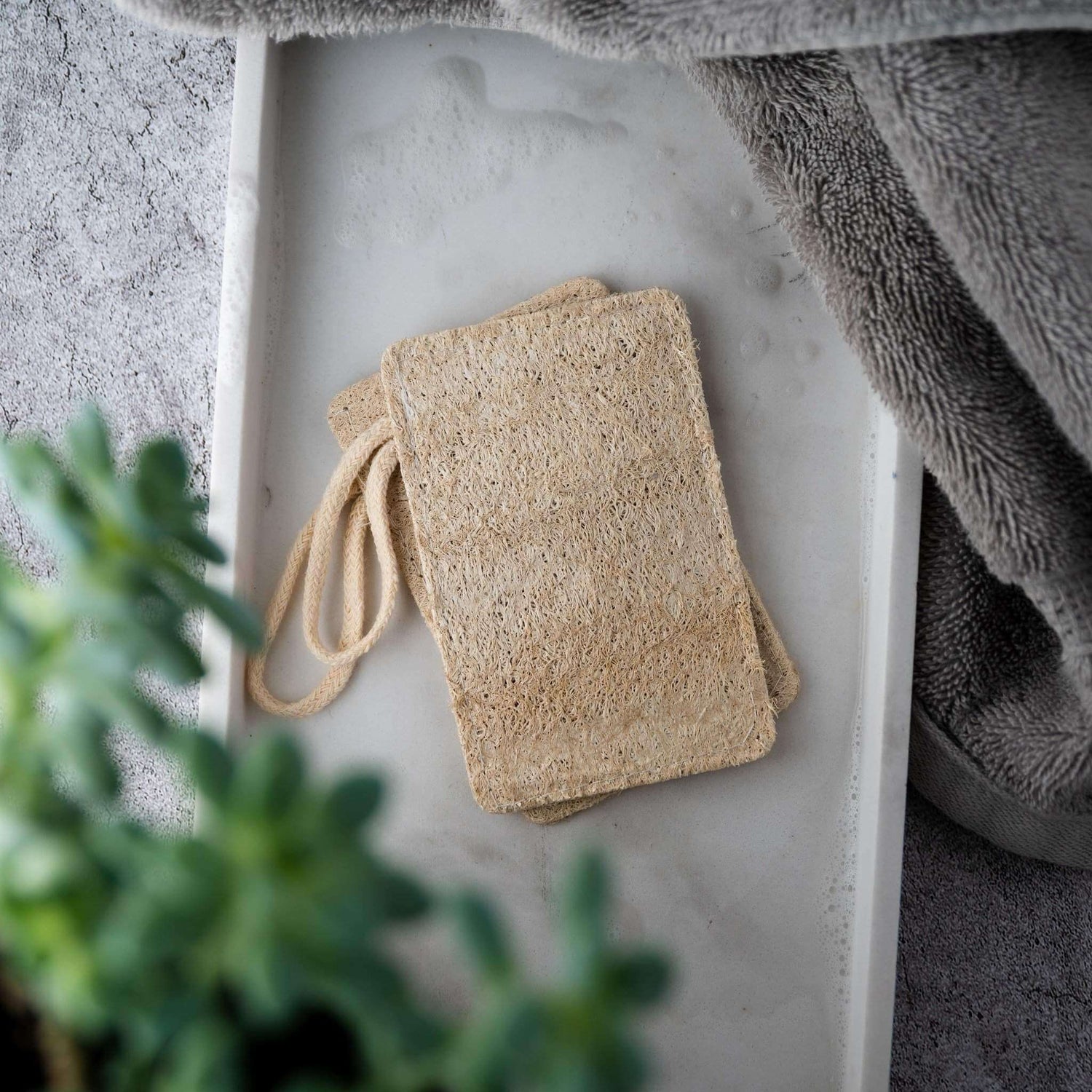 Natural loofah pads on a tray, ideal for exfoliating and promoting healthy, radiant skin. 100% biodegradable.