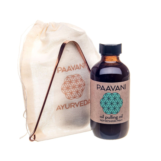 Bottle of Paavani oil pulling oil in refreshing mint flavor, alongside a cotton pouch for oral care rituals.