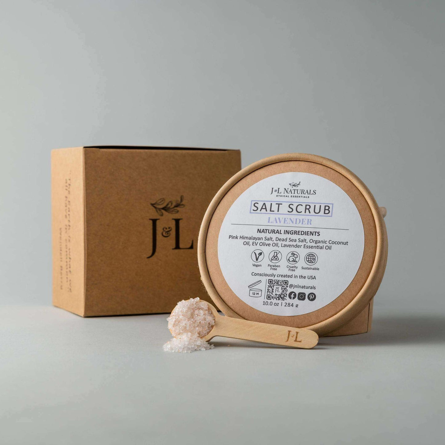 Lavender salt scrub with natural ingredients in eco-friendly packaging, featuring scoop for easy application.