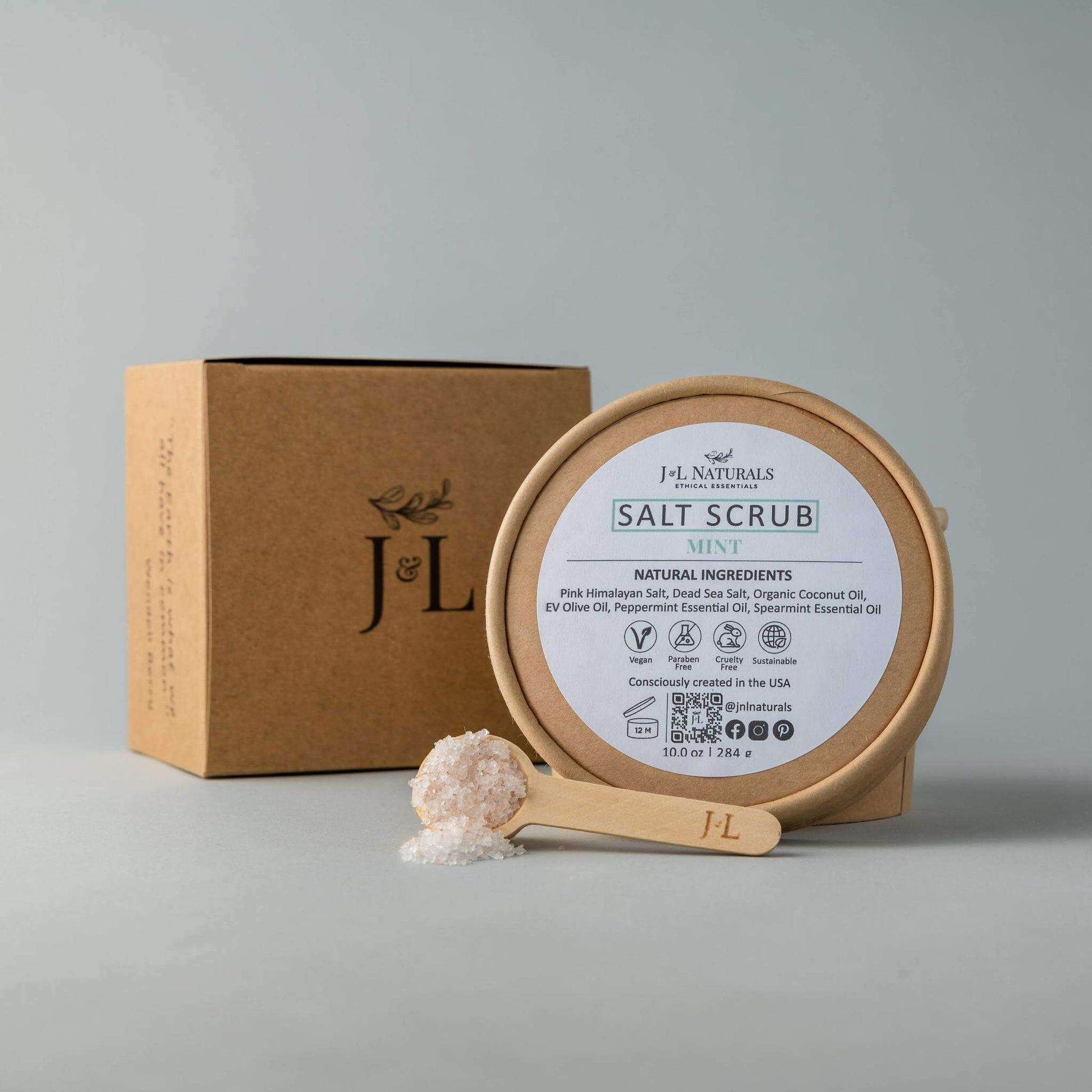 Natural mint salt scrub in a wooden jar with scoop, promoting soft, moisturized skin with Himalayan and Dead Sea salts.