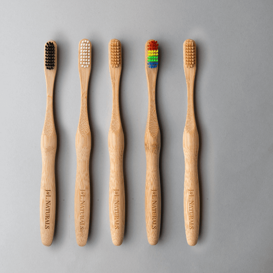 Bamboo toothbrush bundle showing five eco-friendly brushes with varied bristle colors on a light grey background.