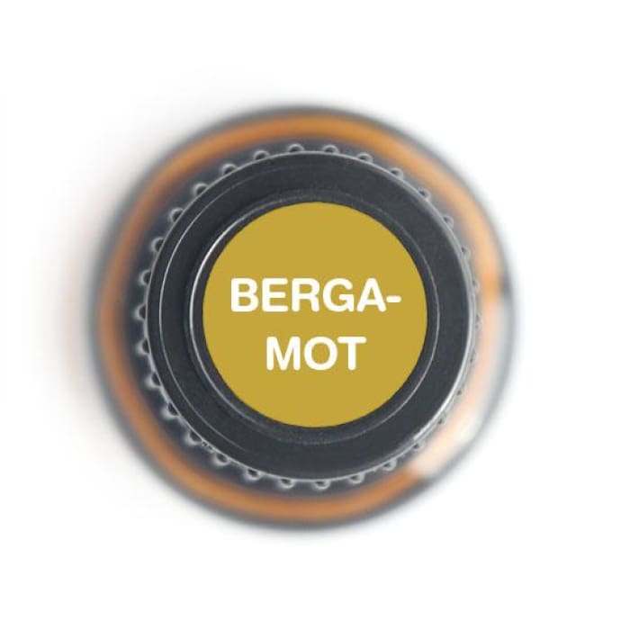 Top view of a bergamot essential oil bottle cap with 'BERGA-MOT' label printed in bold white letters.