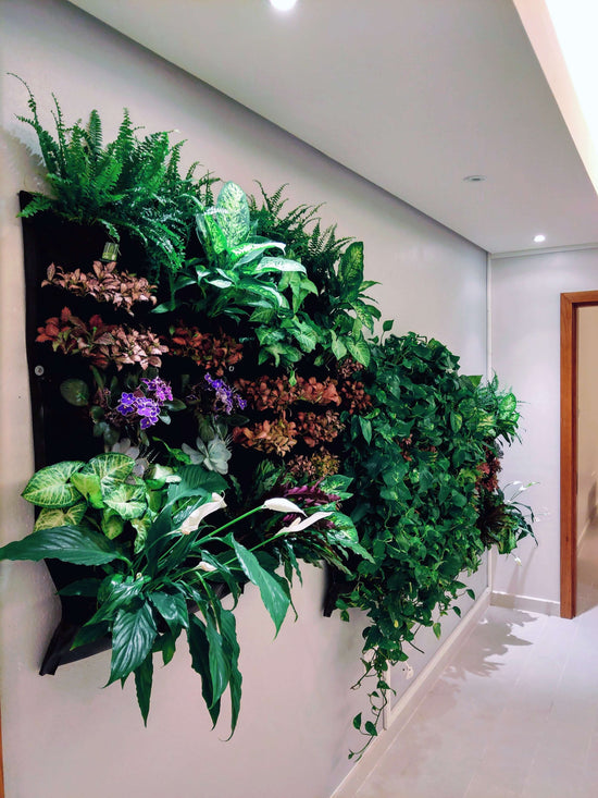 Indoor vertical living wall planter displaying lush greenery and colorful plants, enhancing room aesthetics and air quality.
