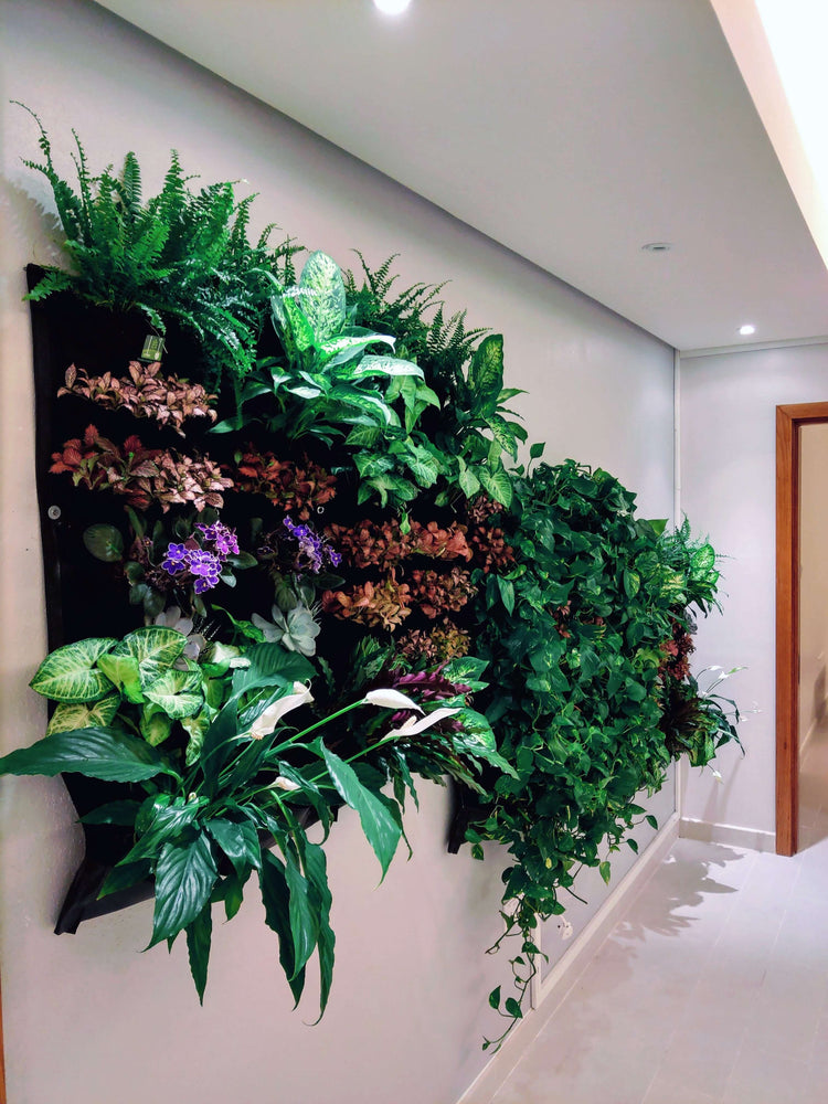 Indoor vertical living wall planter displaying lush greenery and colorful plants, enhancing room aesthetics and air quality.