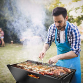 Man grilling skewers on a portable BBQ grill outdoors, surrounded by greenery, showcasing easy setup and cooking features.