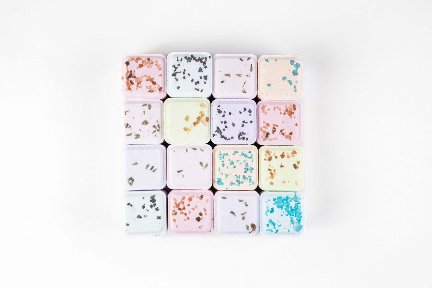 Natural bath bombs and colorful shower steamers arranged in a gift box for a relaxing spa experience.