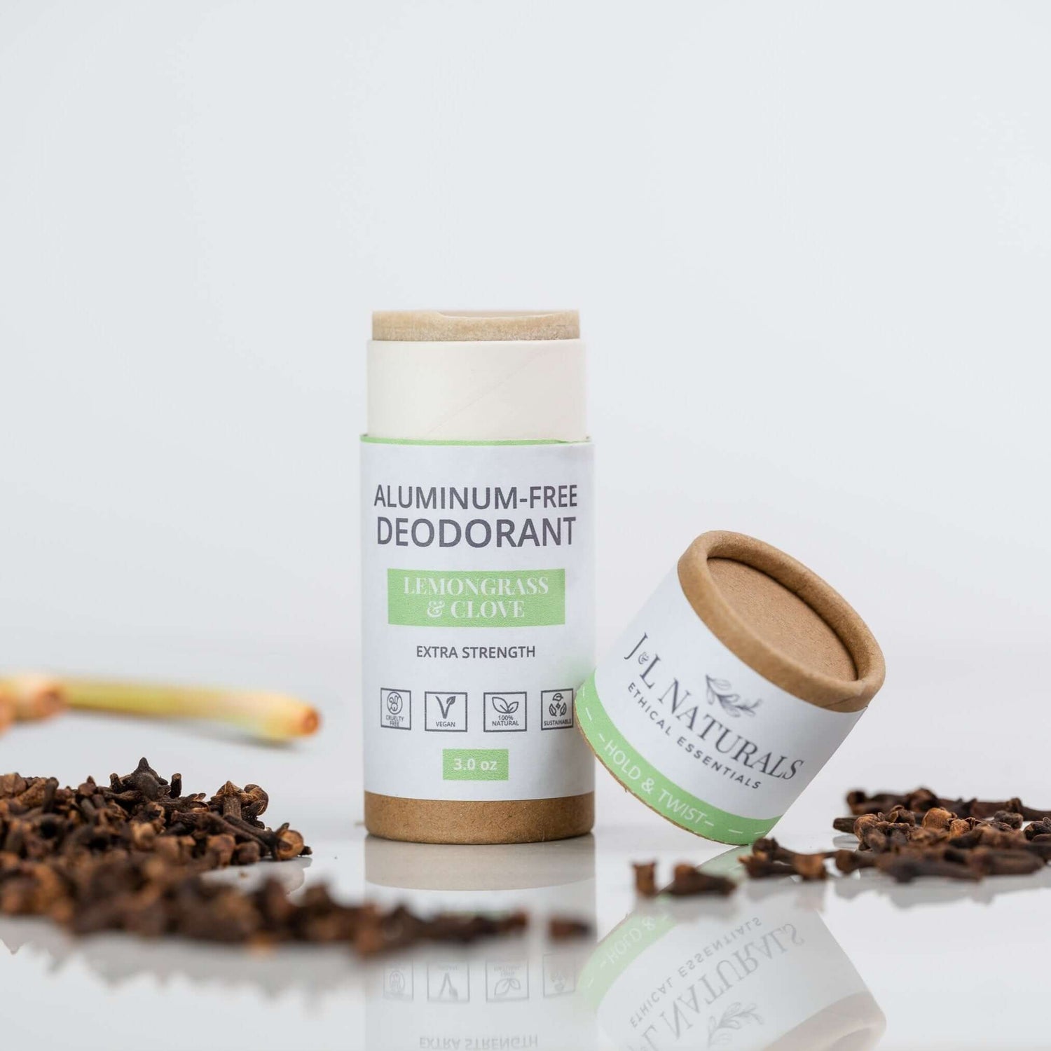 Aluminum-free deodorant stick in Lemongrass & Clove scent, surrounded by cloves and lemongrass for natural odor protection.