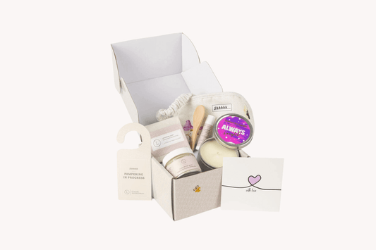 Lavender bath and body gift set with facial mask, soap, candle, lip balm, eye mask, and a personal note.