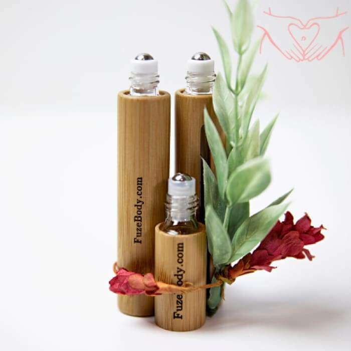 Three bamboo roll-on essential oil bottles with greenery and flowers, ideal for Women's Monthly Comfort.