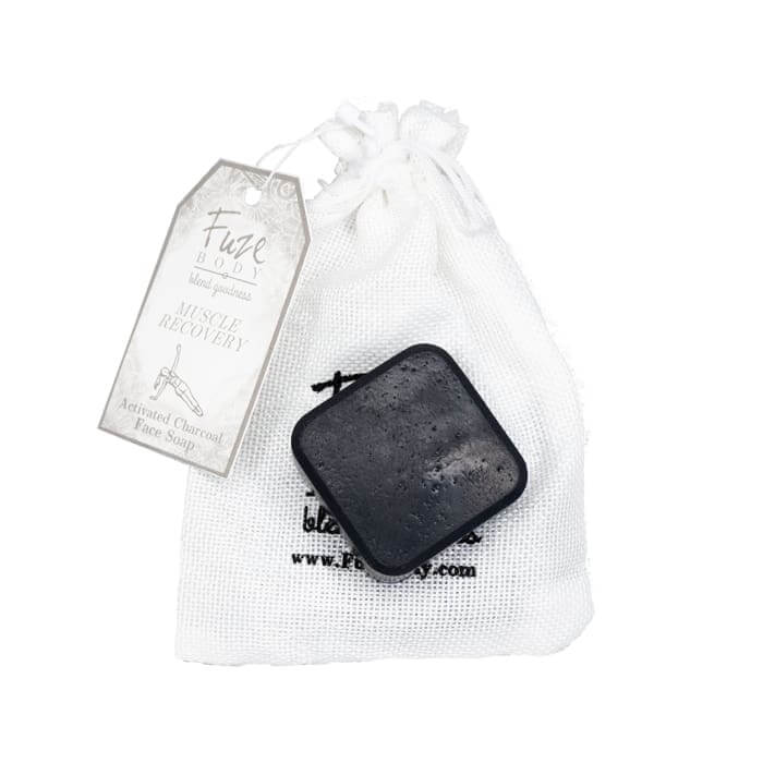 Muscle Recovery Activated Charcoal Facial Soap in a sachet, featuring ingredients like goat milk and essential oils.