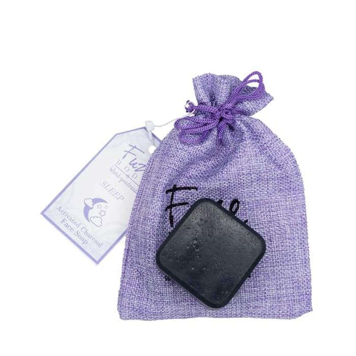 Activated charcoal facial soap in a purple sachet, featuring nourishing goat milk and essential oils for skin care.