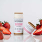 Extra-strength aluminum-free deodorant stick in Strawberry & Vanilla scent, surrounded by fresh strawberries.