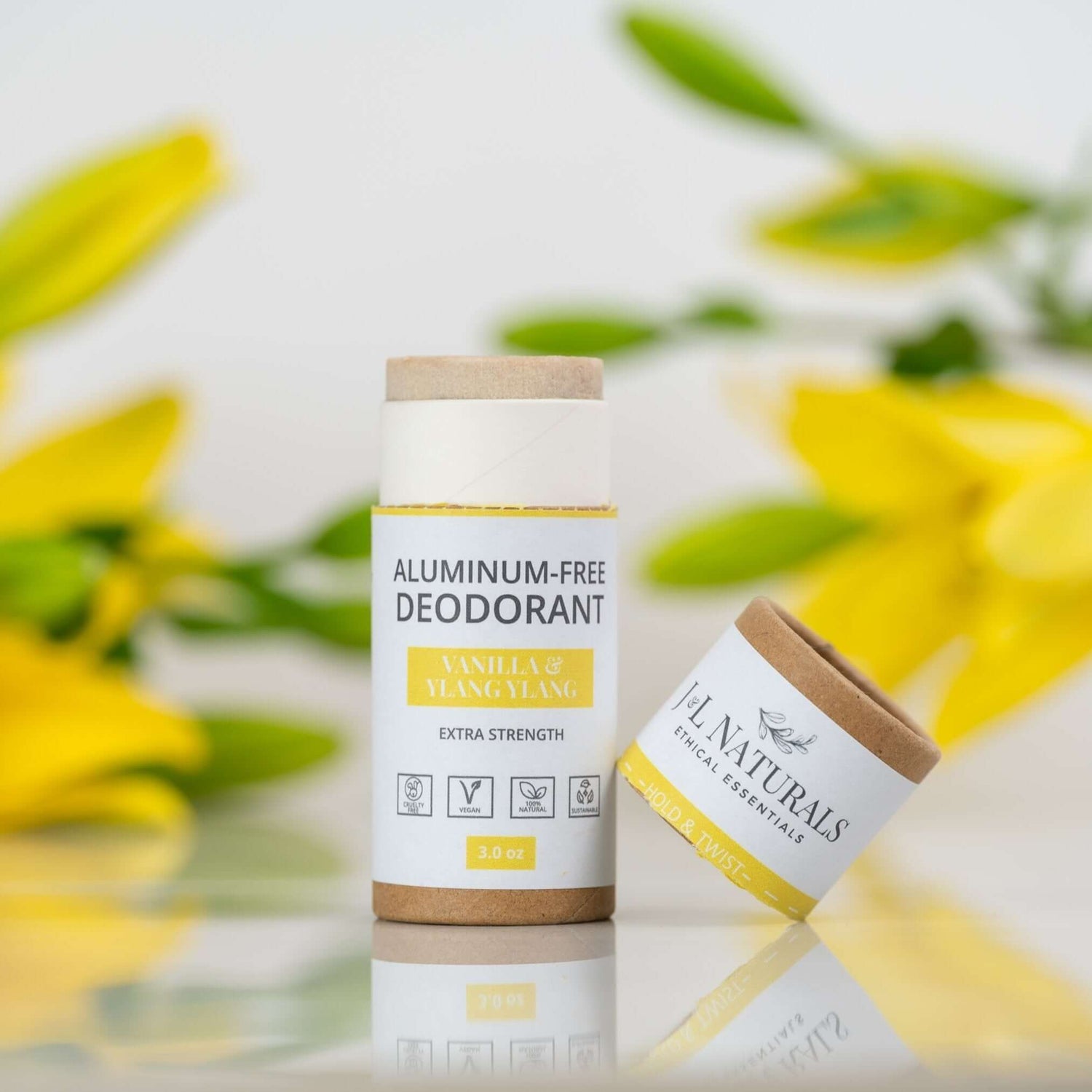 Aluminum-free deodorant stick in vanilla and ylang ylang scent with yellow flowers in the background.