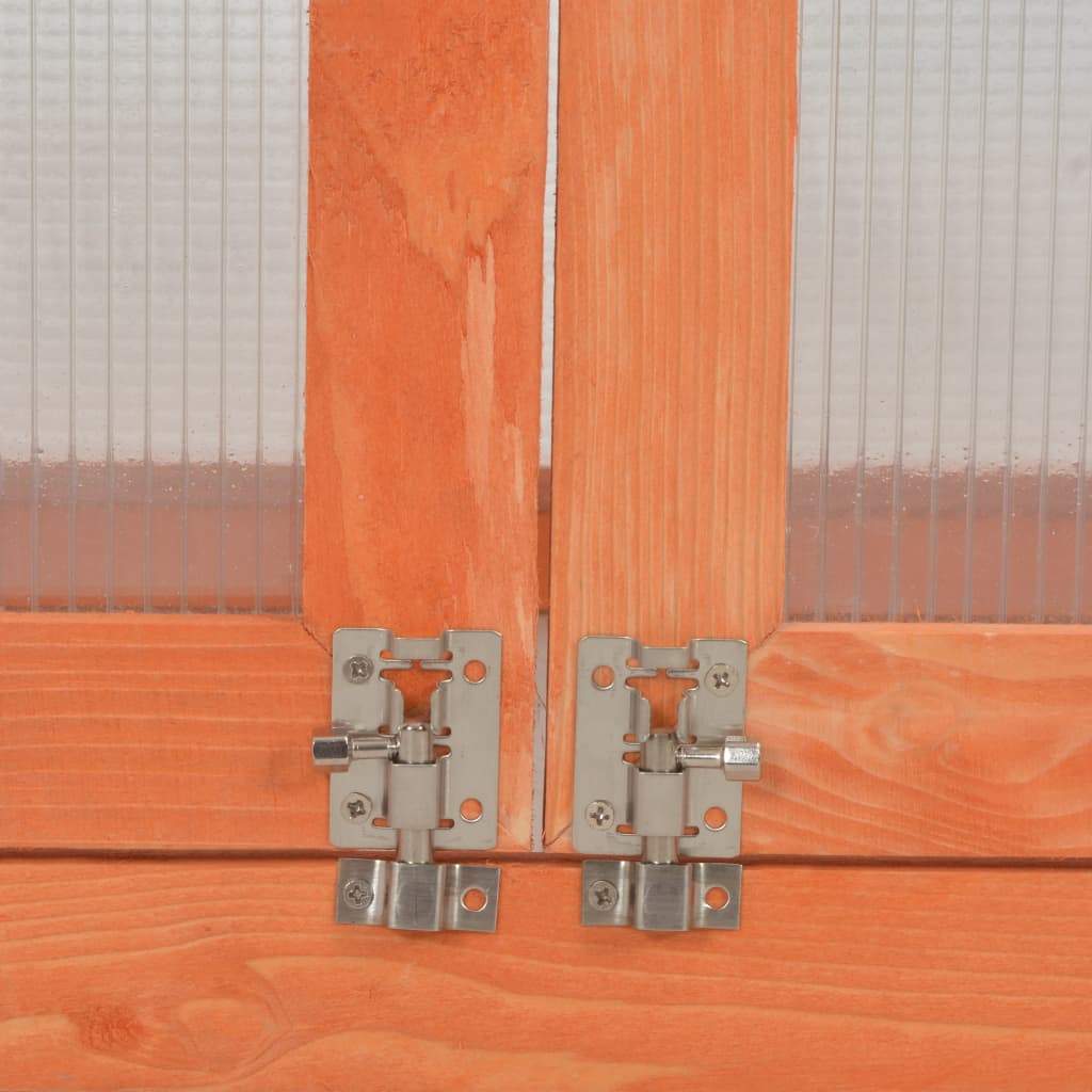 Wooden greenhouse door hinges close-up showing strong metal hardware and PC board panels.