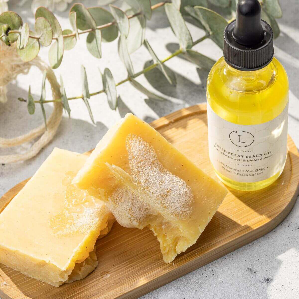 Handmade citrus soap bar and grapefruit body oil on a bamboo tray, perfect for a spa care package.