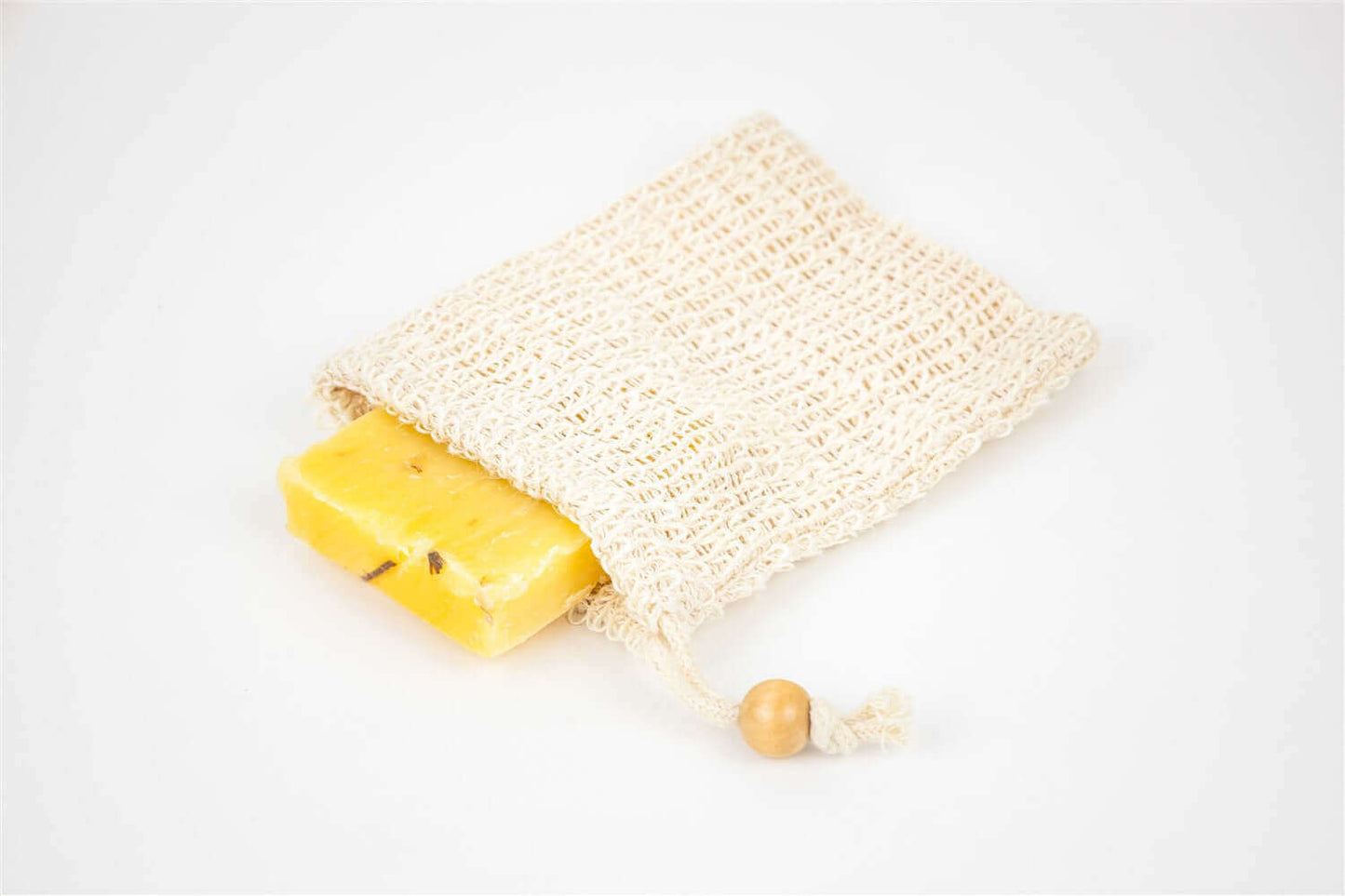 Handmade natural soap bar in a woven drawstring bag, perfect for spa gifts and relaxation care packages.