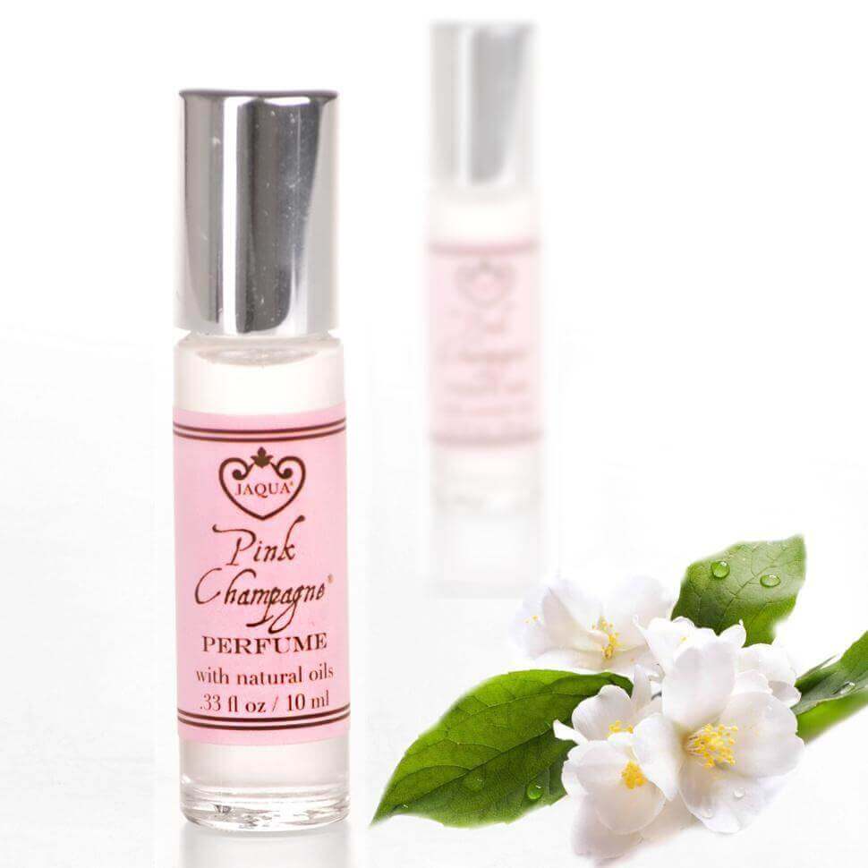 Pink Champagne roll-on perfume oil with natural oils placed beside white jasmine flowers.