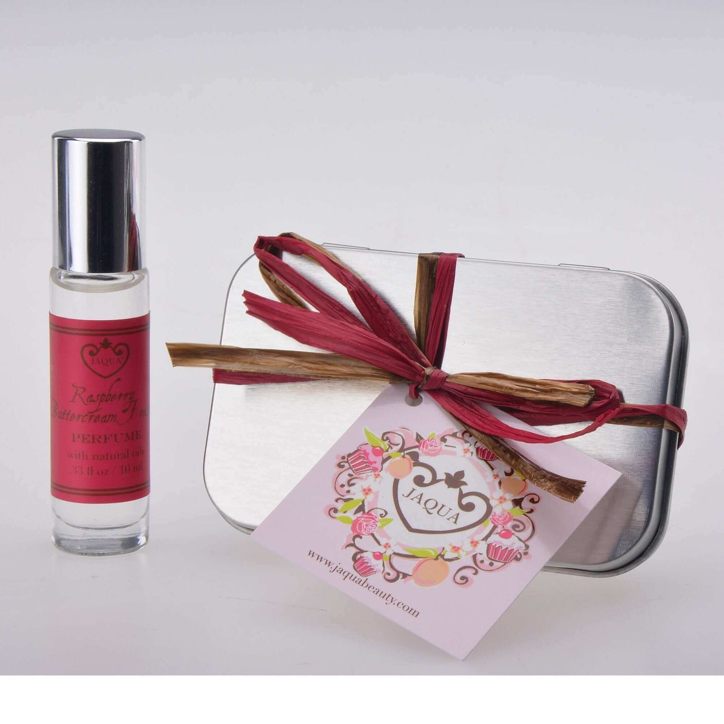 Raspberry Buttercream Frosting roll-on perfume oil in a stylish tin with a gift tag, made with natural oils, in purse-size.