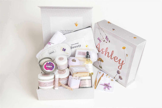 Gift basket featuring lavender bath and body products, including scrubs, oils, and an eye mask, beautifully packaged.