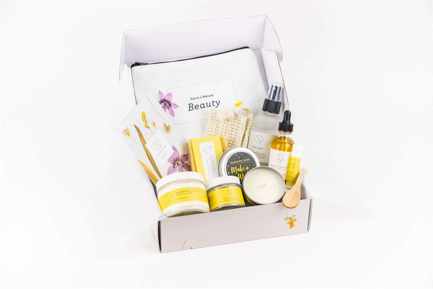 Handmade natural bath and body gift box with cosmetic bag, citrus soap, body oil, scrub, and shower steamer.