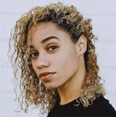 Close-up of a person with curly hair showcasing natural beauty and glossy lips.
